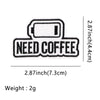 Black embroidered patch with the text NEED COFFEE on a rectangular background.