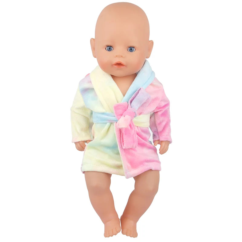 A baby doll wearing a pink and yellow cartoon animal bathrobe set.