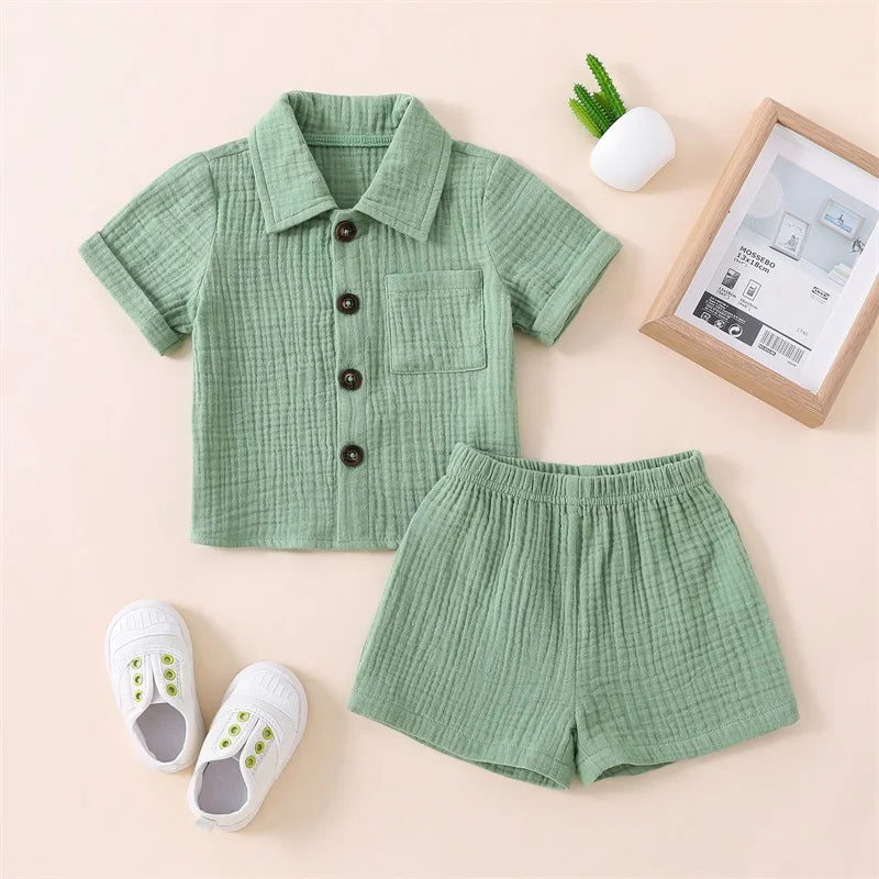 A baby boy cotton linen outfit set featuring a mint green short-sleeved shirt and matching shorts.