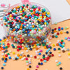 A clear container filled with a large quantity of colorful pony beads in various shades of pink, blue, green, and yellow scat