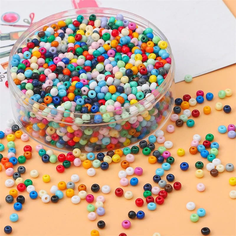 A clear container filled with a large quantity of colorful pony beads in various shades of pink, blue, green, and yellow scat
