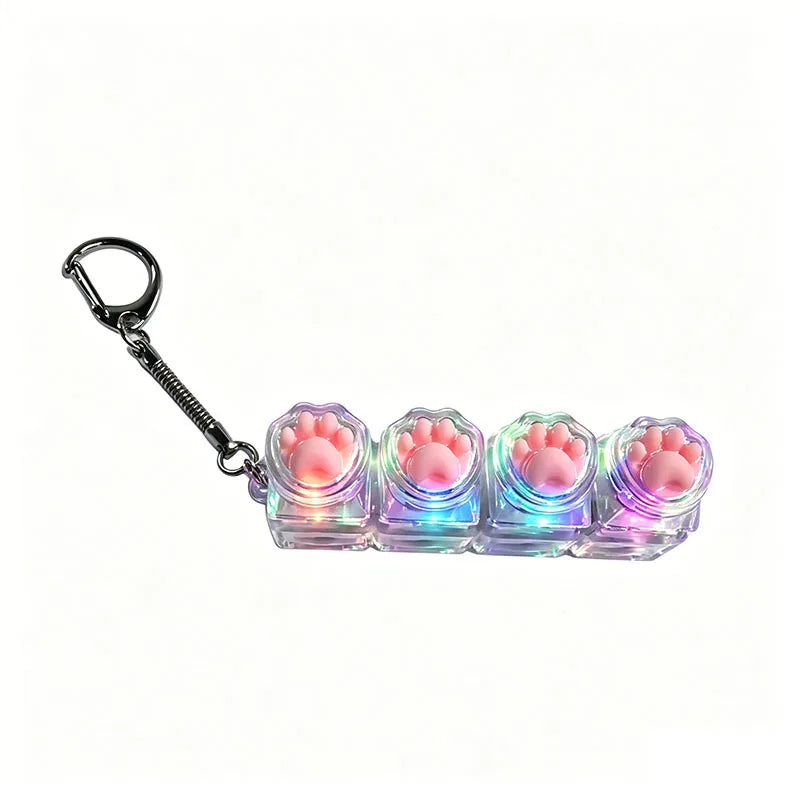 A set of silicone paw print keyboard keychains with LED lights attached to a metal keyring.