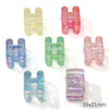 A collection of colorful acrylic alphabet beads in various shades including pink, green, and blue.