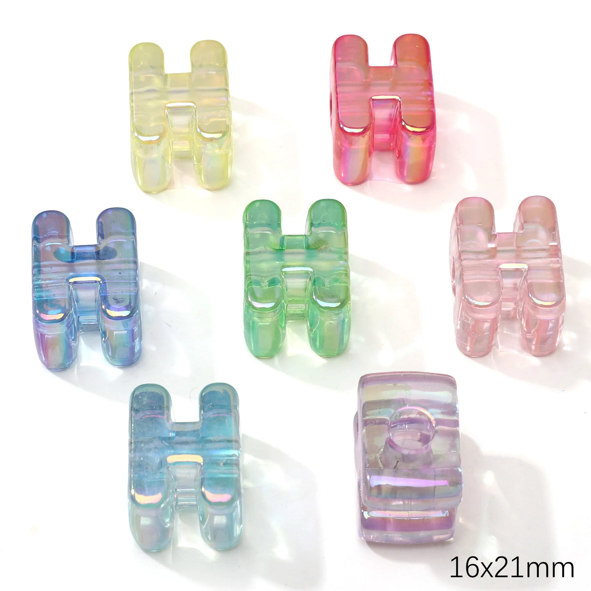 A collection of colorful acrylic alphabet beads in various shades including pink, green, and blue.