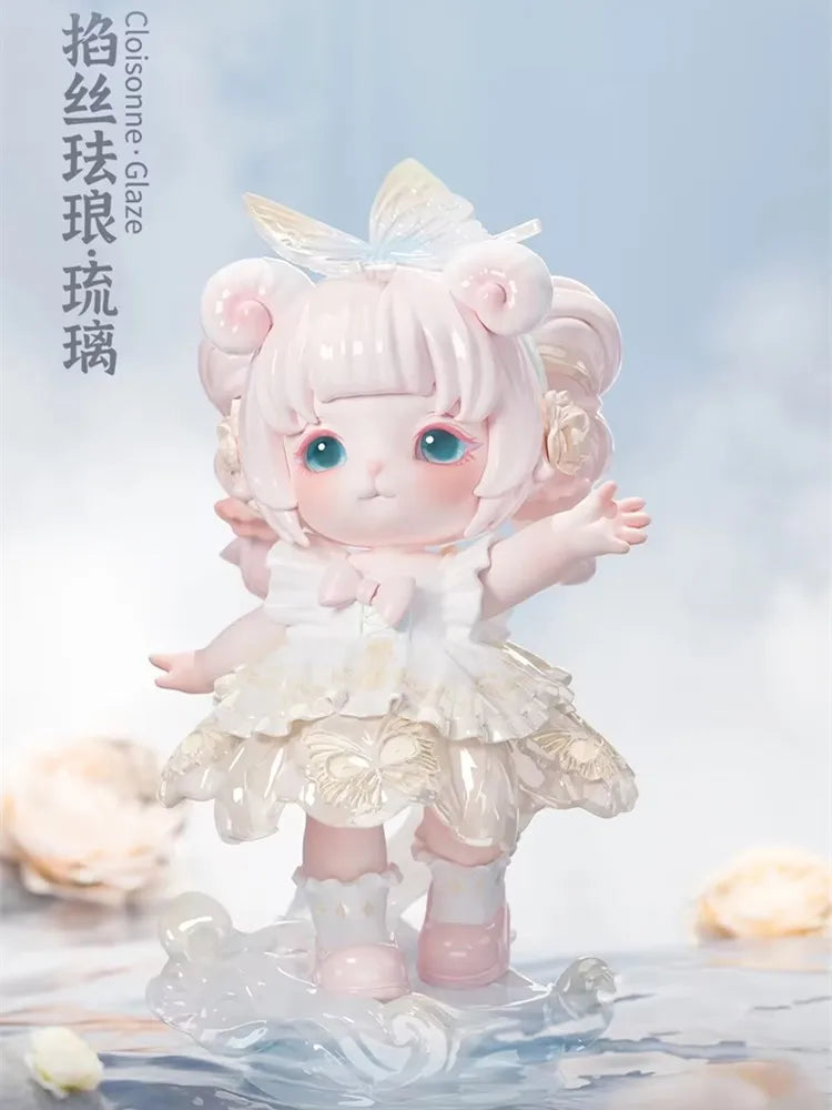 A pink collectible figurine of a girl with light blue eyes and fluffy hair, wearing a white dress, standing on a clear surfac