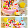 A pink birthday cake with colorful decorations and candles is shown alongside a set of play food items.