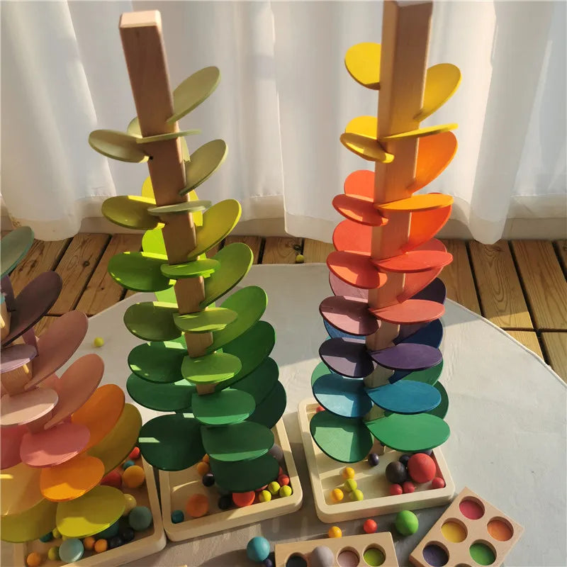 A wooden sensory music tree with a marble run featuring colorful, layered leaves.