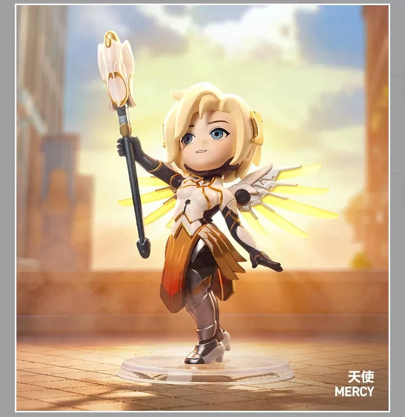 A blonde female Overwatch Play of the Game collectible PVC figurine with golden wings and a staff, standing on a clear base.