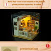 A clear acrylic miniature coffee shop house display with various wooden and paper elements for a DIY dollhouse kit.