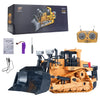 An orange remote control excavator toy with a black bucket and tracks, shown next to its packaging and controller.