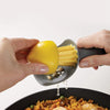 A hand is using a manual citrus juicer to extract juice from a yellow lemon.