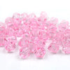 A pile of faceted pink bicone crystal glass beads for jewelry making.
