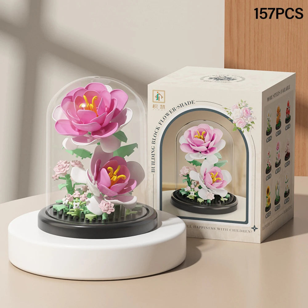 A box of DIY micro building blocks featuring a pink eternal flower garden design with a dust cover and a white base.