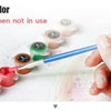 A hand dips a paintbrush in colorful paint to cover a DIY paint by numbers kit when not in use.