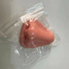 A pink silicone squeeze toy for facial massage or fidget tool is visible inside a clear plastic bag.
