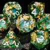 A collection of green polyhedral dice, some covered in gold leaf, are displayed on a dark surface.