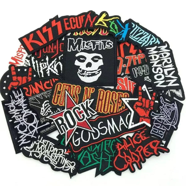 Sammlung schwarzer, bestickter, stickbarer Klebeflächen mit Band- und Rock-Designs.