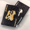 A set of black and gold waterproof playing cards featuring the Joker and Ace of Spades.