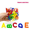 Una mano sostiene una bolsa de letras capitales magnéticas en varios colores, con las letras individuales mostradas abajo.