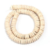 A strand of natural light beige turquoise stone beads coiled into a circular shape for jewelry making