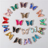 A collection of crystal butterfly charm beads in various shades of green, blue, pink, and gold.