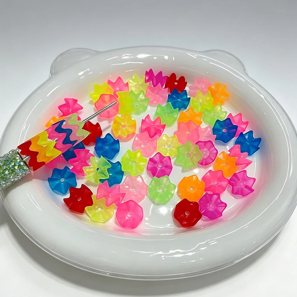 A white dish holds a pile of 300 translucent beads in various bright colors for jewelry making.