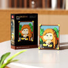 A box and a finished pixel art building block featuring an orange-haired woman.