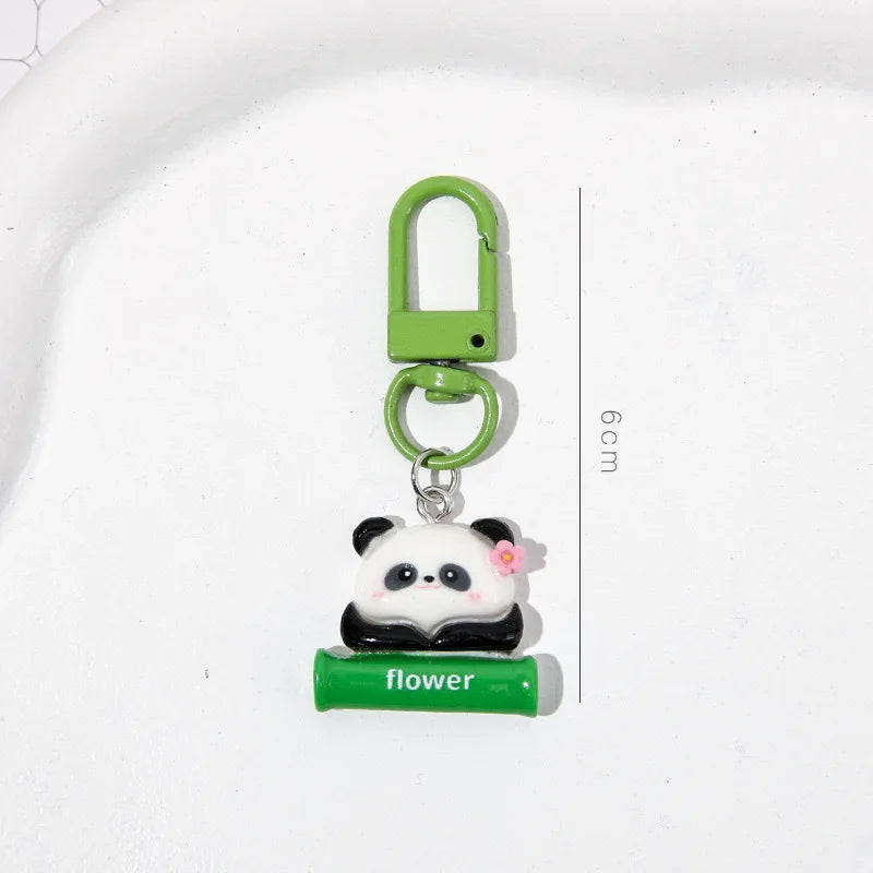 A green padlock keychain featuring a cute panda charm and a small flower, displayed on a white background.
