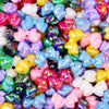 A close-up of colorful acrylic bow beads in various shades including pink, purple, blue, and yellow.