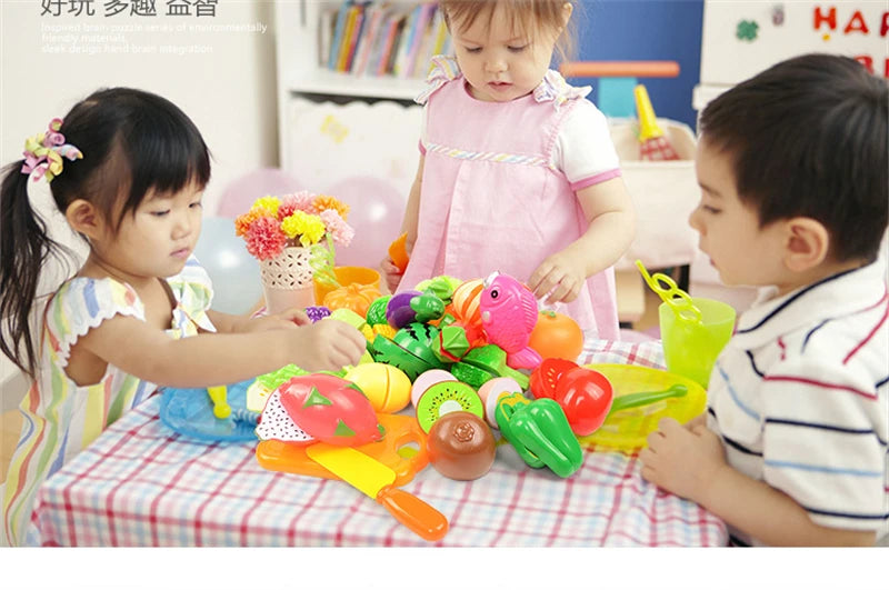 A child is playing with a pretend play kitchen set featuring colorful plastic fruits and vegetables.