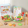 A wooden salad pretend play food set with various colorful vegetables and fruits in a green bowl and accompanying wooden uten