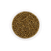 A clear container filled with small round brass or gold-colored glass seed beads for jewelry making.