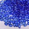 A close-up view of small, brilliant blue water drop Czech glass beads for jewelry making.