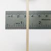 Nahaufnahme eines hellbeigen Messwerkzeugs mit Zentimeter- und Zollmarkierungen.