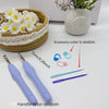 A set of ergonomic crochet hooks, stitch markers, and needles with random colors displayed next to a woven basket and a white