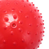A close-up view of a bright red inflatable sensory ball with textured bumps and a small hole.
