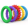 A set of colorful, textured silicone fidget bracelets in green, purple, red, yellow, and blue.