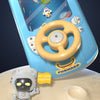 A blue kids interactive steering wheel driving toy with various sound effects buttons and a small white figure.