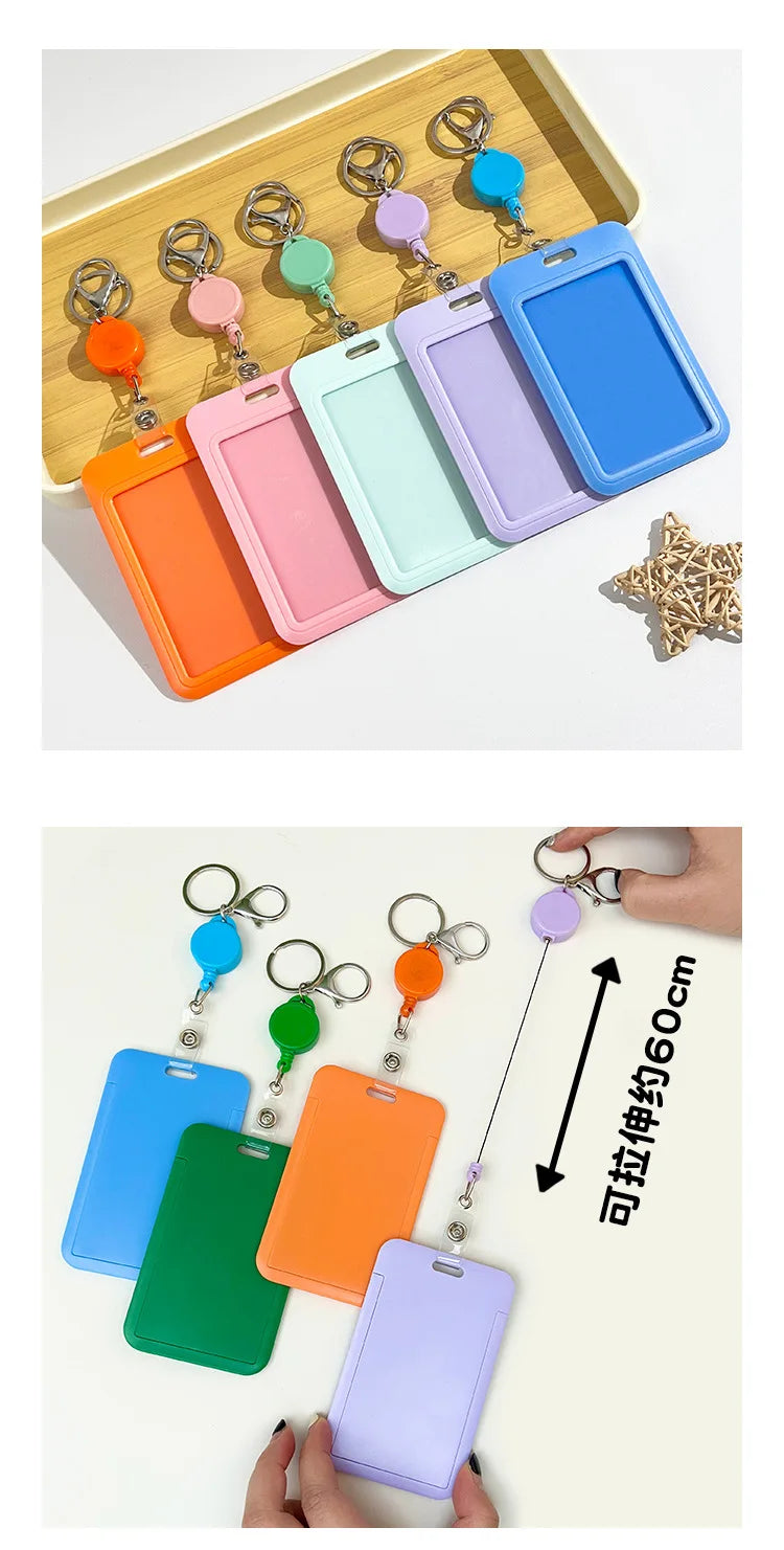 A collection of colorful retractable ID badge holders with keychain clips arranged in a wooden tray and displayed on a white 