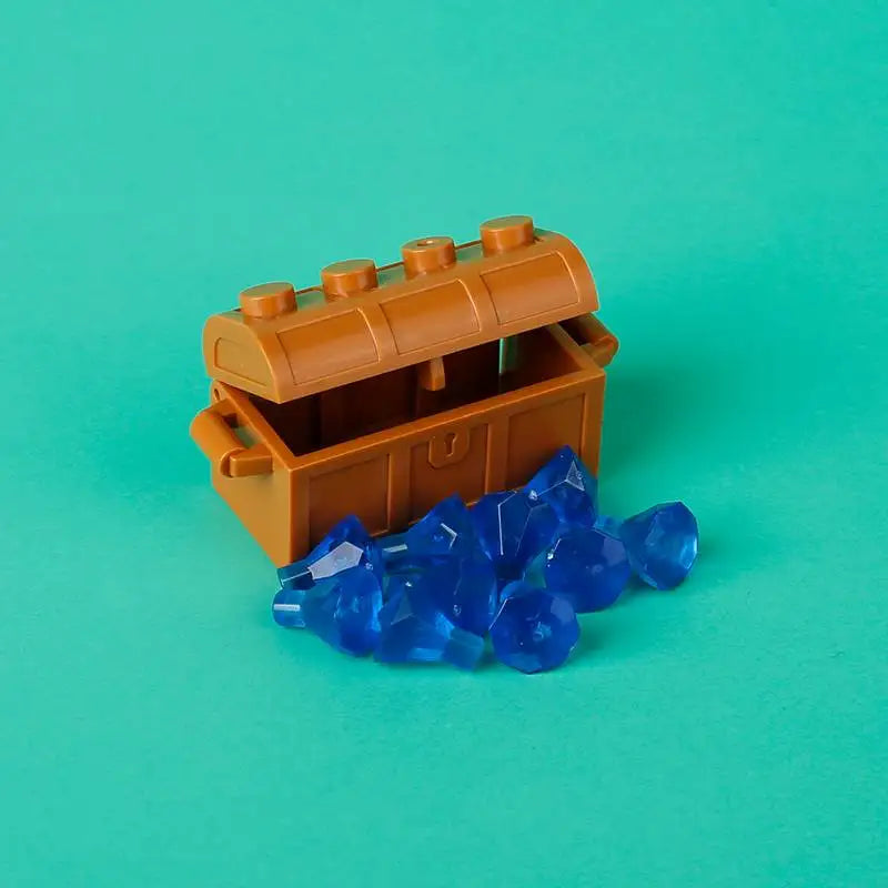 A wooden treasure chest built from building blocks is shown next to blue gemstone-like pieces on a teal background.