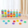 Wooden ring toss game with colored wooden rings and pegs arranged in a row for sorting or stacking.