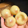 Five smooth, yellow squishy stress relief clay fidget toys are held in a person's hand.