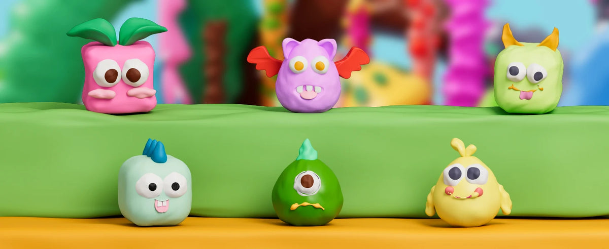 A collection of colorful polymer clay sculptures, including a pink, purple, green, and yellow face, displayed on a green surf