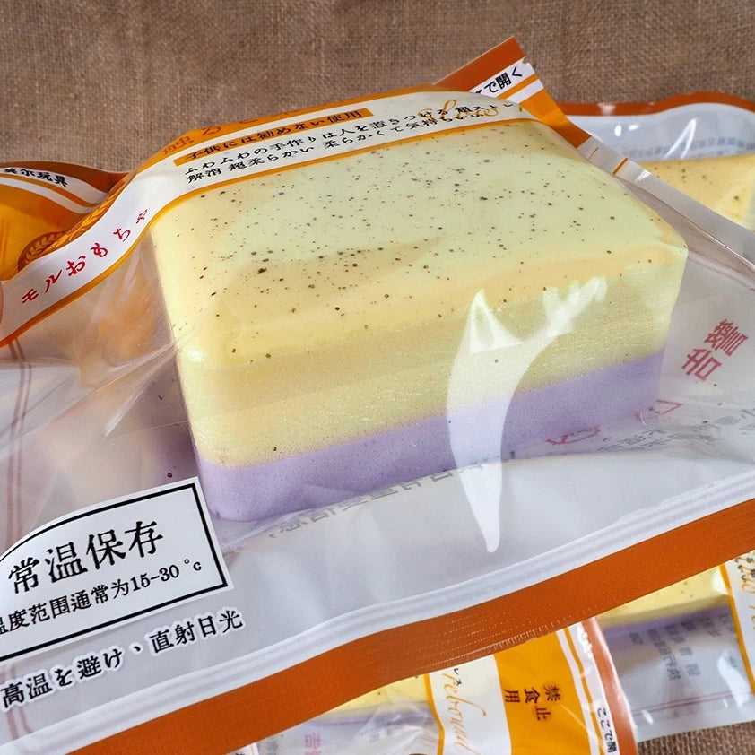 A block of yellow and purple squishy stress relief toy, likely a slow-rise toast product.