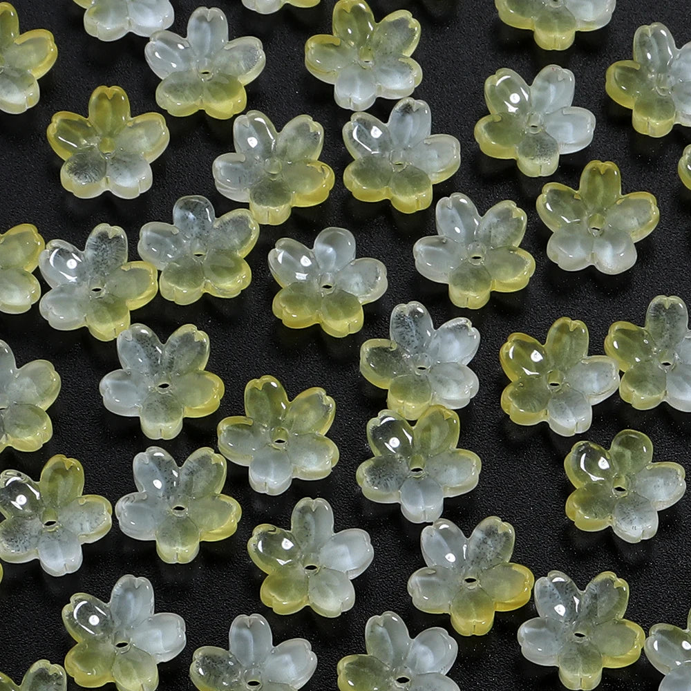 A collection of small, translucent light green glass flower beads for jewelry making
