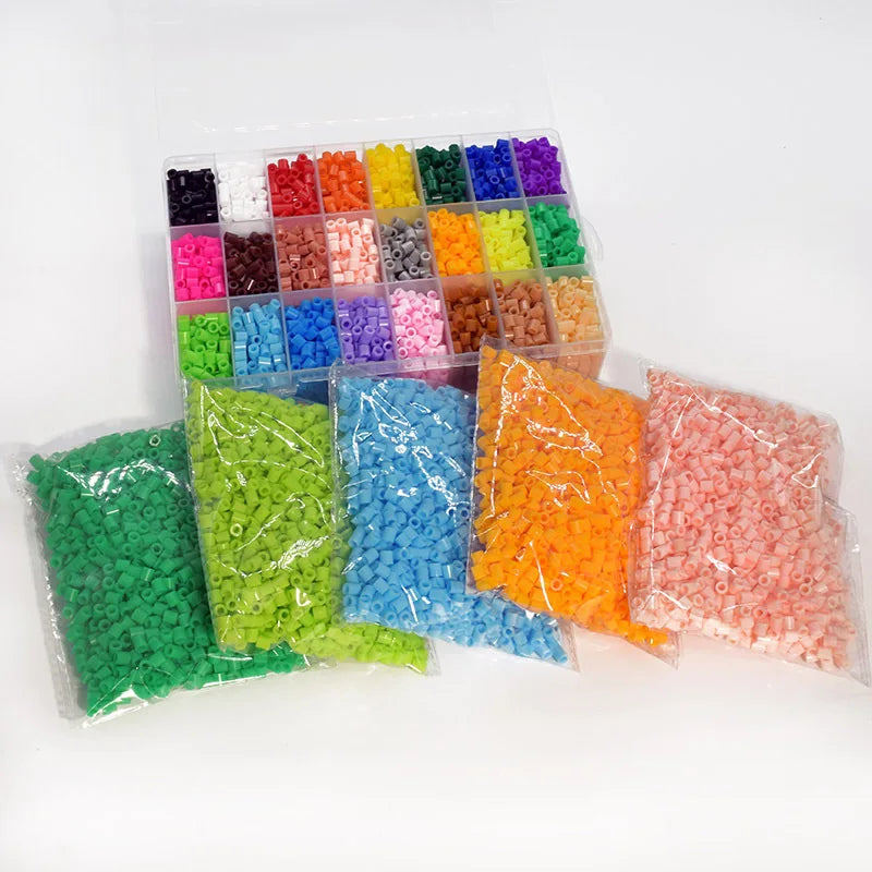 A clear plastic box filled with various colored fuse beads for crafting, including green, yellow, orange, pink, and blue.