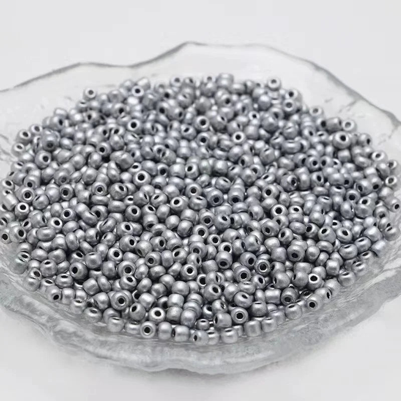 A pile of 2400 glass seed beads in various colors is displayed in a translucent dish for jewelry making.