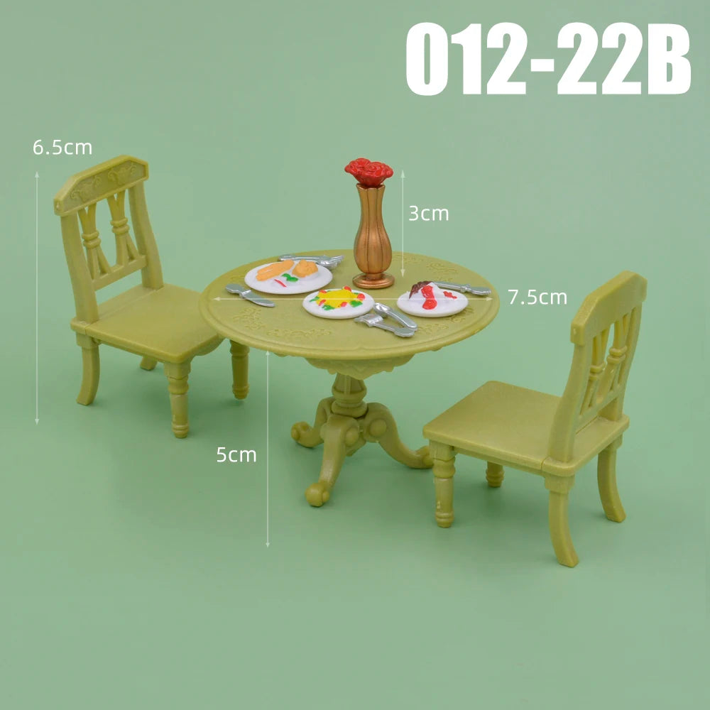 A dollhouse furniture playset featuring a light green wooden chair, a round table, and a small vase with a red flower.