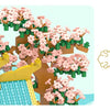 A micro building block set depicting a retro Chinese villa with pink blossoms, a tiled roof, and a courtyard garden.