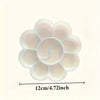 A close-up view of a flower-shaped disposable paint palette with a translucent white and pink hue.